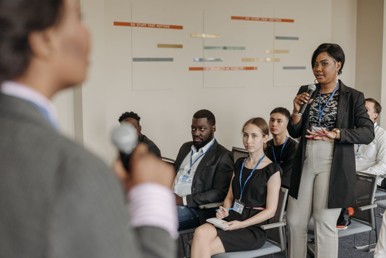 Engaged business discussion at a conference with diverse professionals participating.